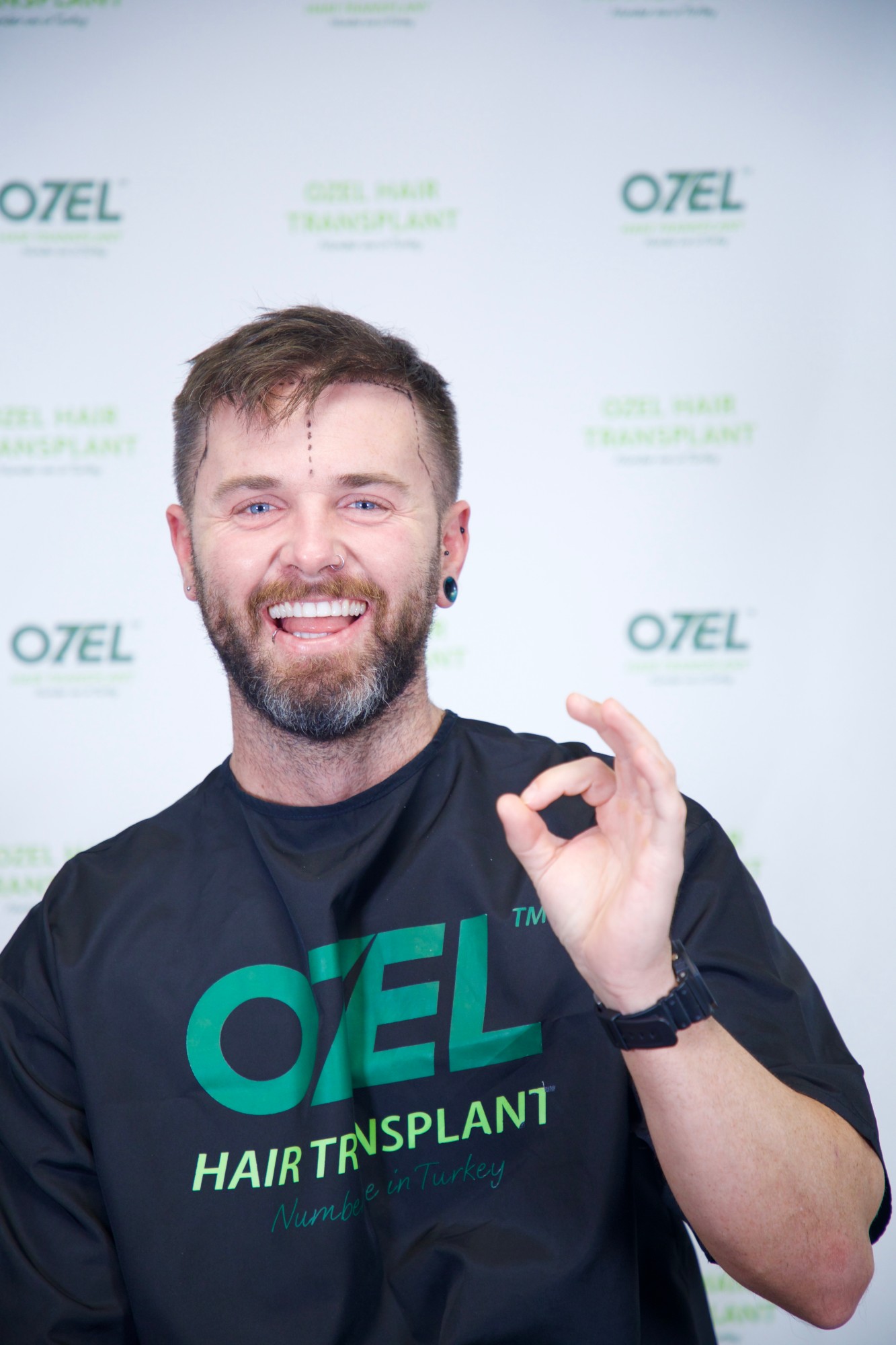 A smiling OZEL client giving the OK sign